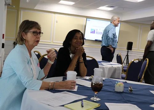 group of women sitting at round table during a regional meeting