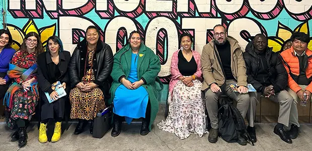Group photo in front of the Indigenous Roots building mural