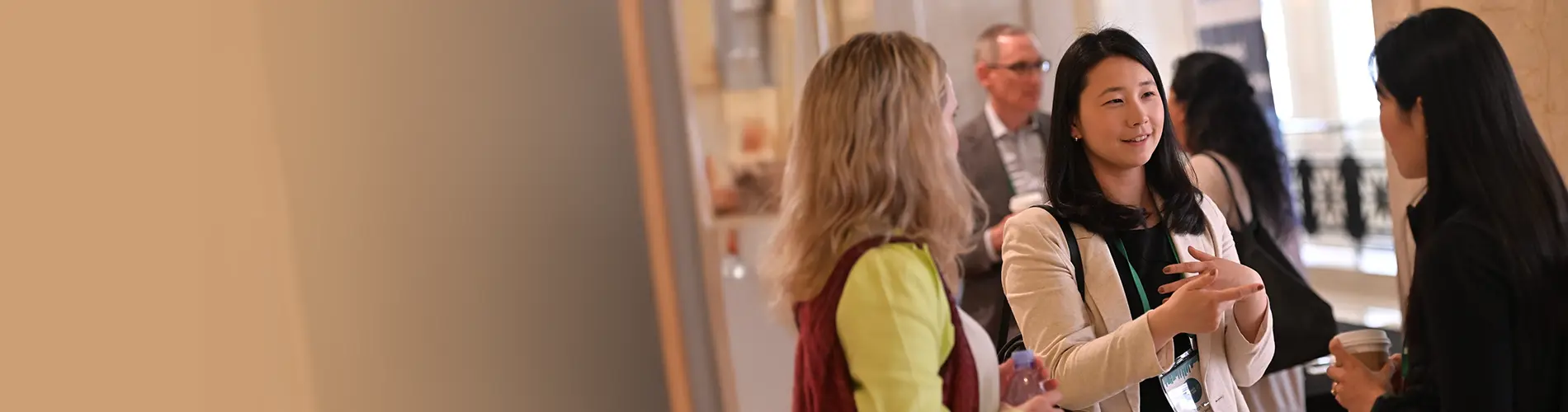 Three women talking in a group at a conference.