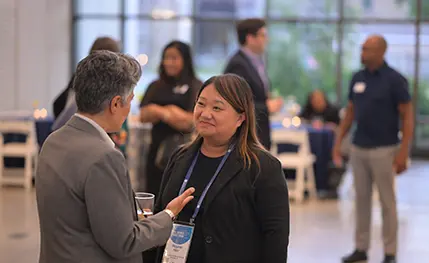 Two people talking with each other at a conference.