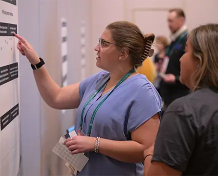 OFN conference attendee using index finger to point at text on a wall chart
