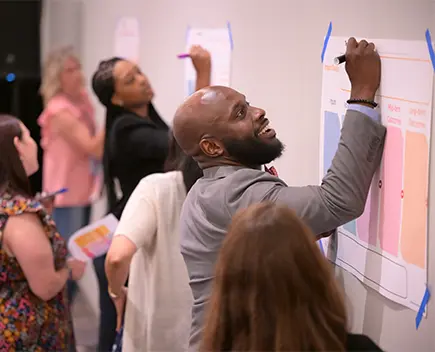 OFN Conference attendees writing on a wall chart