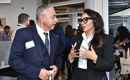 Bespeckled woman in suit conversing with a man in a suit