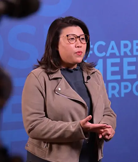 Woman speaking in front of Career Meets Purpose Backdrop